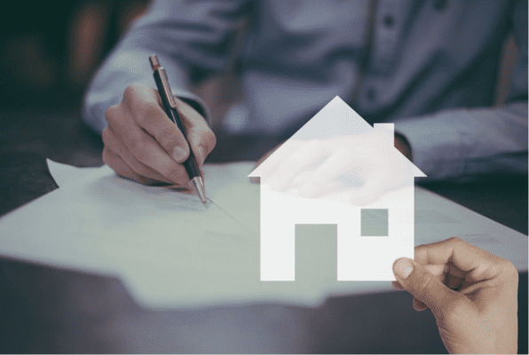 A person writing on some paper. A hand holding a white icon of a home is laid over the image